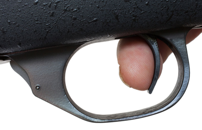 Finger on the trigger of a rifle being used for target shooting