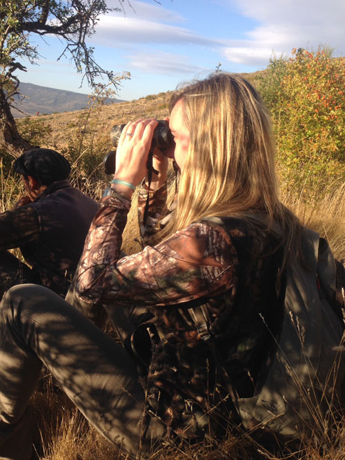 Woman in camo looking through binoculars