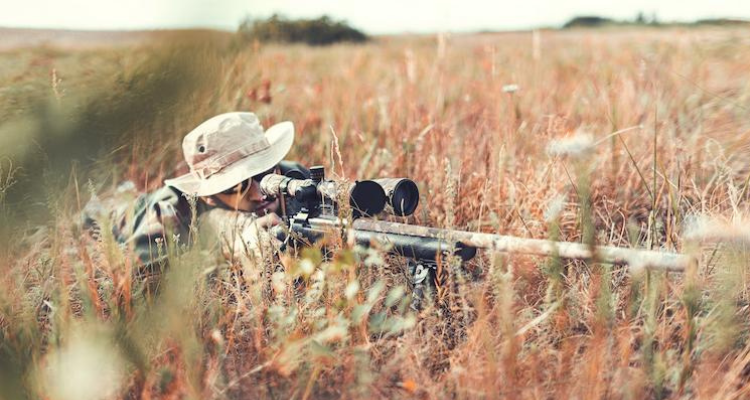 Man with a hunting rifle in the prone position