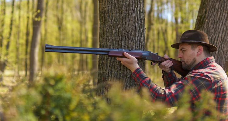 Man holding a hunting rifle in the forest