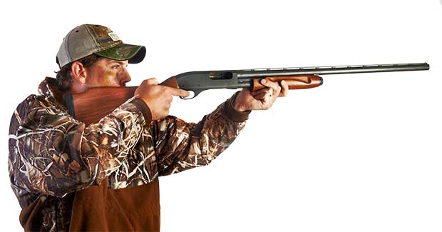 man-in-camo-aiming-shotgun man in camouflage aiming shotgun