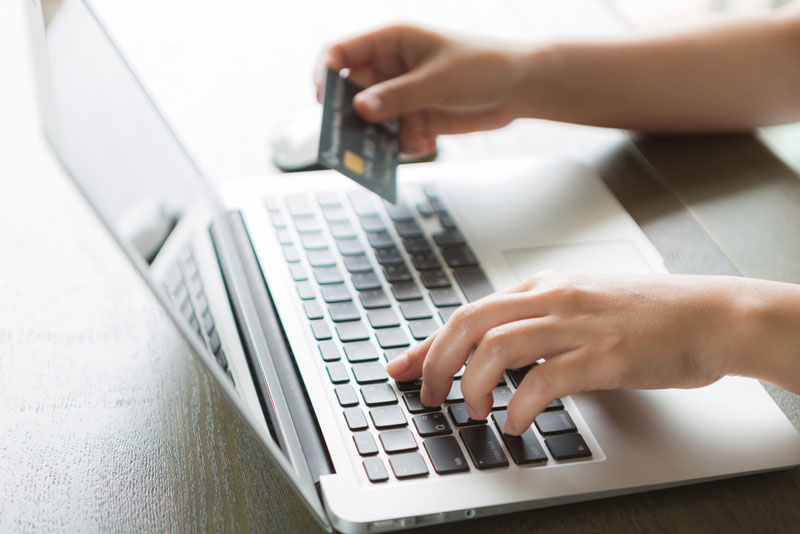 Man on laptop with credit card making a transaction